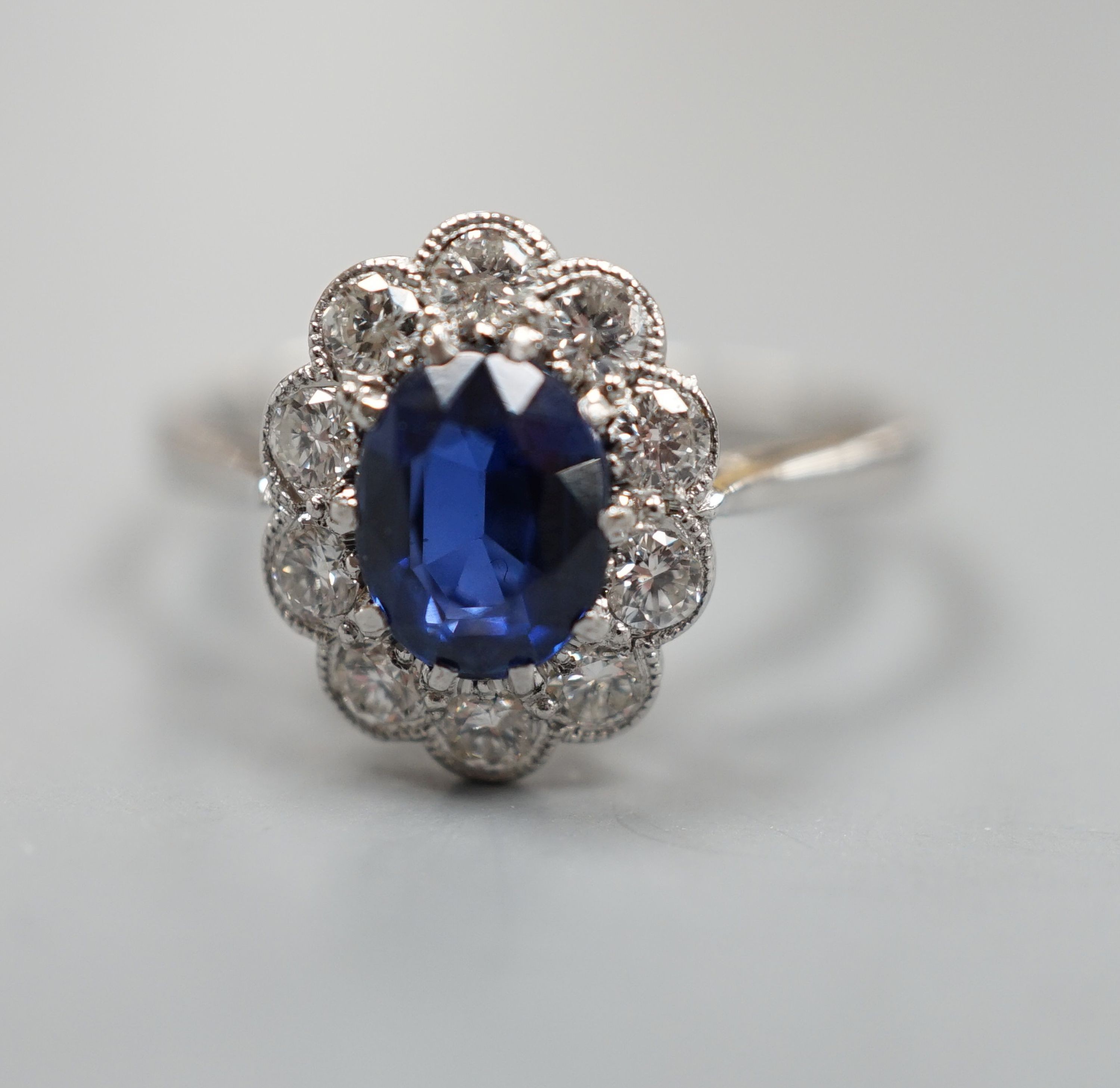 An 18ct and plat. sapphire and diamond set oval cluster ring, size N, gross weight 2.9 grams.